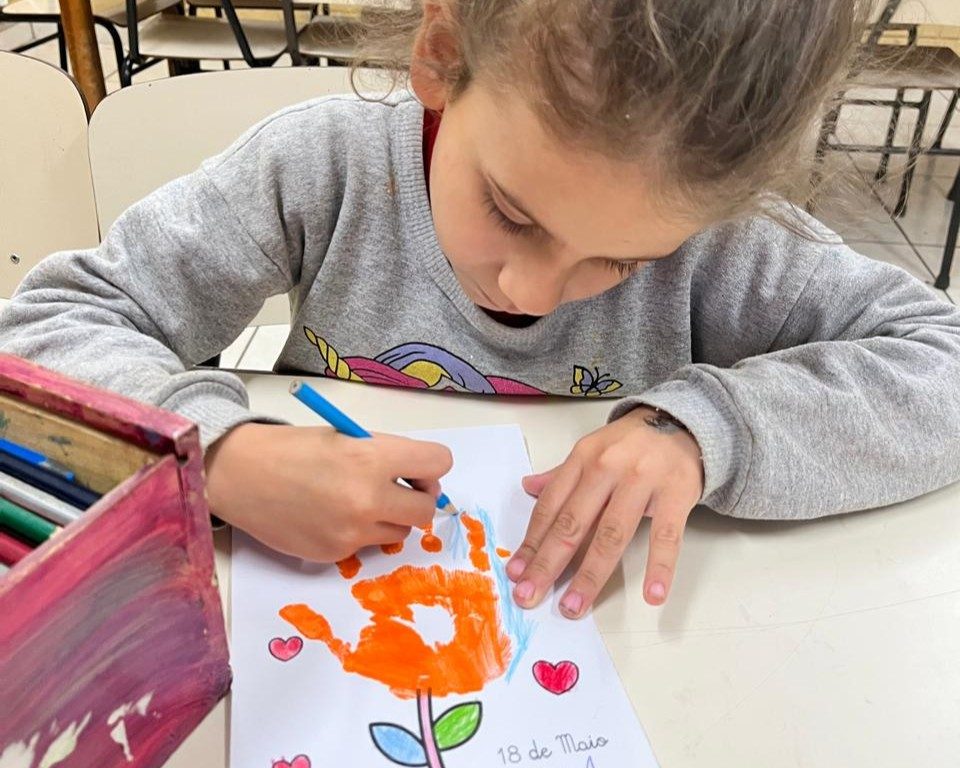 Crianças com lápis de cor e desenhos na Casa de Dom Bosco